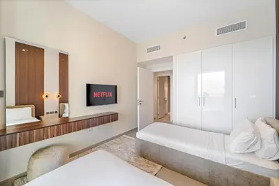 a white bedroom with a bed and a tv at Luxury 4BR with full Burj Khalifa and Fountain View - 5Min to Dubai Mall in Dubai