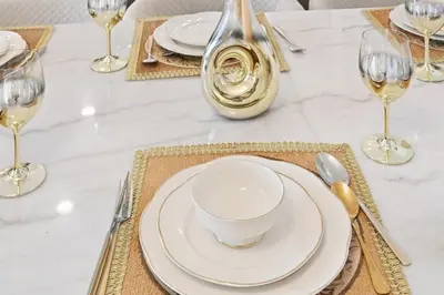a table with white plates and wine glasses on it at Burj Khalifa View Next to Dubai Mall Sleeps 12 in Dubai