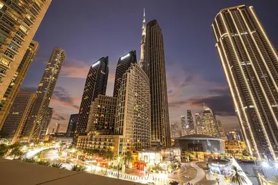 a view of a city at night with tall buildings at Burj Khalifa View Next to Dubai Mall Sleeps 12 in Dubai