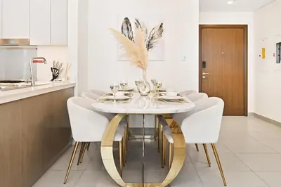 a dining room with a white table and chairs at Burj Khalifa View Next to Dubai Mall Sleeps 12 in Dubai