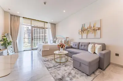 a living room with a couch and a table at Furnished Studio with Burj Khalifa View, Near Dubai Water Canal, with Easy Access to Downtown, Peninsula Five - 3, Business Bay by Deluxe Holiday Homes in Dubai