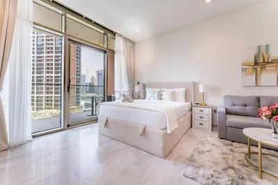 a bedroom with a bed and a couch at Furnished Studio with Burj Khalifa View, Near Dubai Water Canal, with Easy Access to Downtown, Peninsula Five - 3, Business Bay by Deluxe Holiday Homes in Dubai