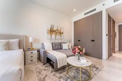 a bedroom with a bed and a couch and a table at Furnished Studio with Burj Khalifa View, Near Dubai Water Canal, with Easy Access to Downtown, Peninsula Five - 3, Business Bay by Deluxe Holiday Homes in Dubai