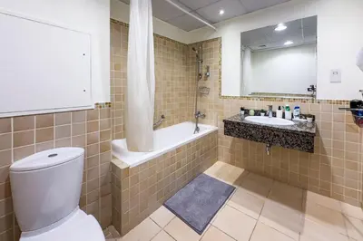 a bathroom with a toilet and a tub and a sink at 2 Bedroom Apts in JBR Shams 1 by Luxaura in Dubai