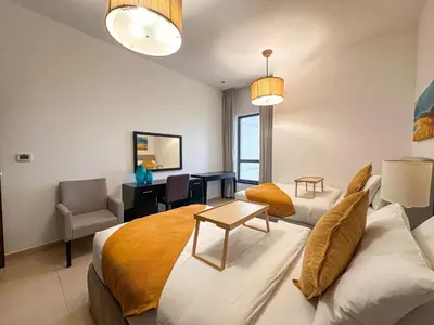 a bedroom with a bed and a couch and a desk at 2 Bedroom Apts in JBR Shams 1 by Luxaura in Dubai