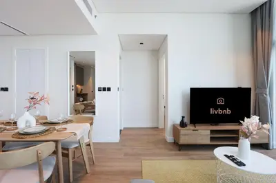 a living room with a table and a tv at Chic 1B by Dubai Canal Marasi Drive with Pool, Gym in Dubai