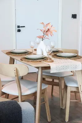 a dining room table with plates and wine glasses at Chic 1B by Dubai Canal Marasi Drive with Pool, Gym in Dubai