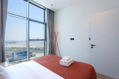 a bedroom with a bed with a large window at Chic 1B by Dubai Canal Marasi Drive with Pool, Gym in Dubai