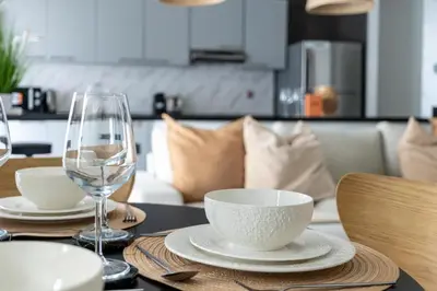 a table with two wine glasses and bowls on it at GuestReady - Spectacular Marina Views | High Floor in Dubai