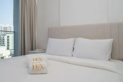 a white bed with a pillow sitting on top of it at Chic and Bright JVC 1 Bed in Catch Residences in Dubai