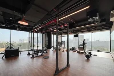 a gym with a bunch of exercise equipment and windows at Chic and Bright JVC 1 Bed in Catch Residences in Dubai