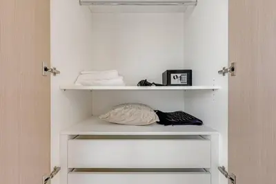 a closet with white shelves and a door at Highest floor - 5 mins walk to Dubai Mall and Burj Khalifa in Dubai