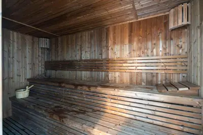 an empty wooden sauna with a bucket in it at GuestReady - Spacious 1Bed l Near Butterfly Garden in Dubai