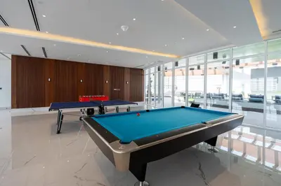 two pool tables in a room with glass windows at GuestReady - Spacious 1Bed l Near Butterfly Garden in Dubai