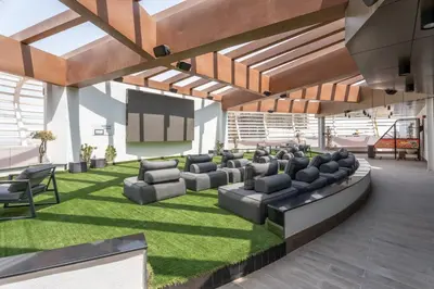 a large living room with couches and a screen at GuestReady - Spacious 1Bed l Near Butterfly Garden in Dubai