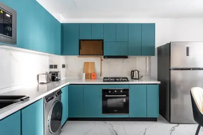a kitchen with blue cabinets and a dishwasher at GuestReady - Spacious 1Bed l Near Butterfly Garden in Dubai
