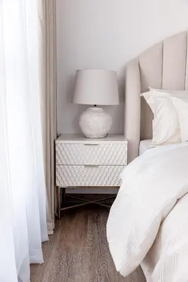 a white bedroom with a bed and a lamp on a night stand at 2 bedroom with a full sea view ! BAHAR in Dubai