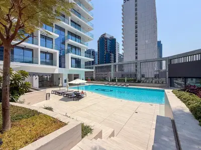 a swimming pool in front of a building at GuestReady - Dubai Skyline & Canal View | 1 BHK in Dubai