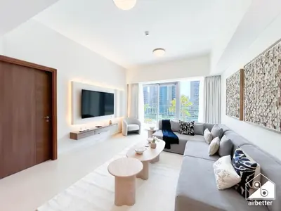 a living room with a couch and a tv at Luxurious 1BR with Balcony & Premium Stay in Downtown in Dubai