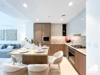 a kitchen and living room with a table and chairs at Luxurious 1BR with Balcony & Premium Stay in Downtown in Dubai