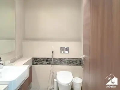 a white bathroom with a toilet and a sink at Luxurious 1BR with Balcony & Premium Stay in Downtown in Dubai
