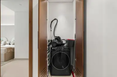 a room with a washing machine in a closet at Private Pool Retreat Chic 2BR Sleeps 8 in Dubai