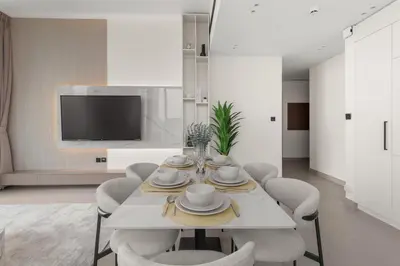 a dining room with a white table and chairs at Private Pool Retreat Chic 2BR Sleeps 8 in Dubai