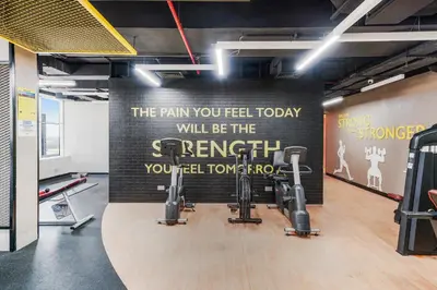 a gym with exercise equipment on the wall at Cozy Studio at walking distance from Burj Khalifa and Downtown Dubai in Dubai