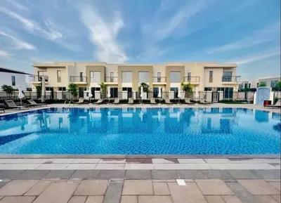 a large swimming pool with chairs and a building at Bright & Stylish 4BR Villa in Dubai