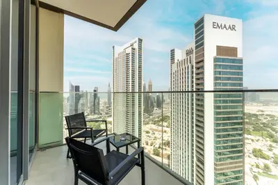 a balcony with two chairs and a view of the city at HAVN - 2 bedroom in Downtown Views Dubai in Dubai