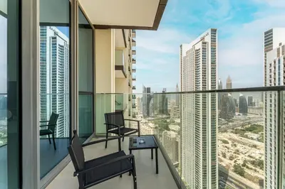 an apartment balcony with chairs and a view of the city at HAVN - 2 bedroom in Downtown Views Dubai in Dubai