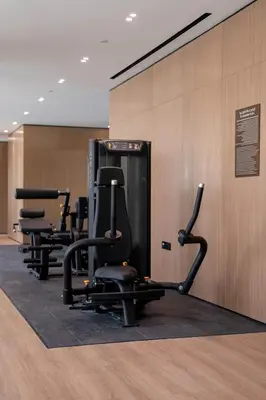 a row of exercise equipment in a gym at Stylish High-Floor Studio in Binghatti Azure! in Dubai