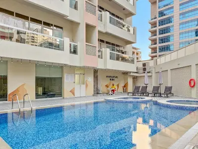 a swimming pool in front of a building at FIRST CLASS Studio Cozy Marble Elegance in Dubai