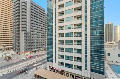 a tall white building with a street in front of it at FIRST CLASS Studio Cozy Marble Elegance in Dubai