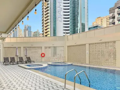a pool on top of a building with tall buildings at FIRST CLASS Studio Cozy Marble Elegance in Dubai
