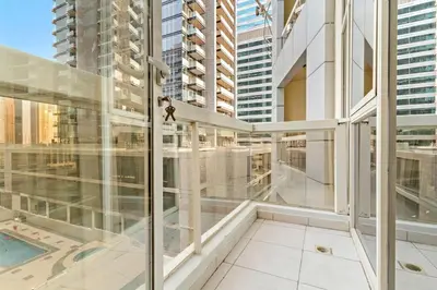 a glass balcony with a view of a building at FIRST CLASS Studio Cozy Marble Elegance in Dubai