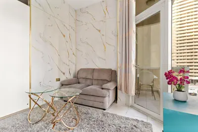 a living room with a couch and a glass table at FIRST CLASS Studio Cozy Marble Elegance in Dubai