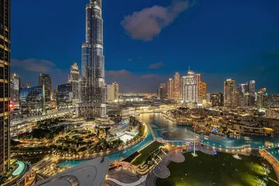 a city skyline at night with a tall skyscraper at FIRST CLASS 1BR Burj Khalifa & Skyline Views in Dubai