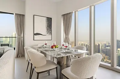 a dining room with a table and chairs and windows at FIRST CLASS 1BR Burj Khalifa & Skyline Views in Dubai