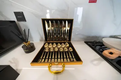 a box of utensils sitting on a counter next to a stove at Fully Furnished I Circle Mall I Sleeps 4 in Dubai