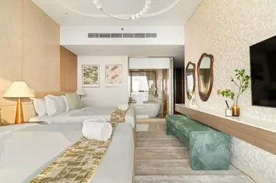 a hotel room with two beds and a bathroom at FIRST CLASS 4BR Elegant Beach House Retreat in Dubai