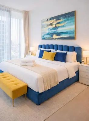 a large bed with a blue headboard in a bedroom at Sleeps 4 I Pool I Circle Mall I Epic Pool in Dubai