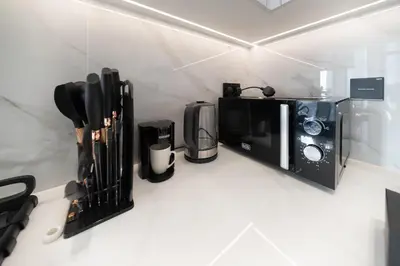 a kitchen counter with a microwave and a coffee maker at Sleeps 4 I Pool I Circle Mall I Epic Pool in Dubai
