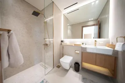 a bathroom with a toilet and a sink and a shower at Sleeps 4 I Pool I Circle Mall I Epic Pool in Dubai
