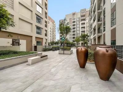 two large brown vases are sitting in a courtyard at FIRST CLASS 1BR Creek Beach & Lagoon Escape in Dubai