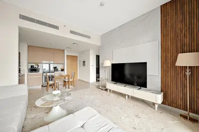 a living room with a large flat screen tv at FIRST CLASS 1BR Creek Beach & Lagoon Escape in Dubai