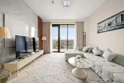 a living room with a couch and a flat screen tv at FIRST CLASS 1BR Creek Beach & Lagoon Escape in Dubai