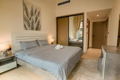 a bedroom with a large bed and a television at Apartment in Binghatti Crescent, Next to Circle Mall in Dubai