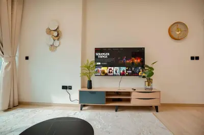 a living room with a flat screen tv on a white wall at Apartment in Binghatti Crescent, Next to Circle Mall in Dubai