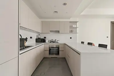 a white kitchen with white cabinets and a counter at FIRST CLASS 3BR Luxury Meets Tranquility in Dubai